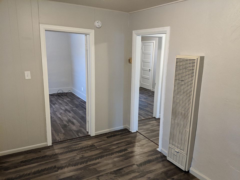 Living area looking into bedroom one(left) and kitchen(right) to second bedroom(back).