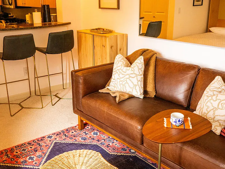 West elm leather couch, west elm leather bar stools, west elm rug, and west elm C table.