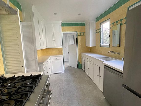 Gas range & oven, hood, dishwasher, French door refrigerator, corian countertops, disposal, terrazzo tiles