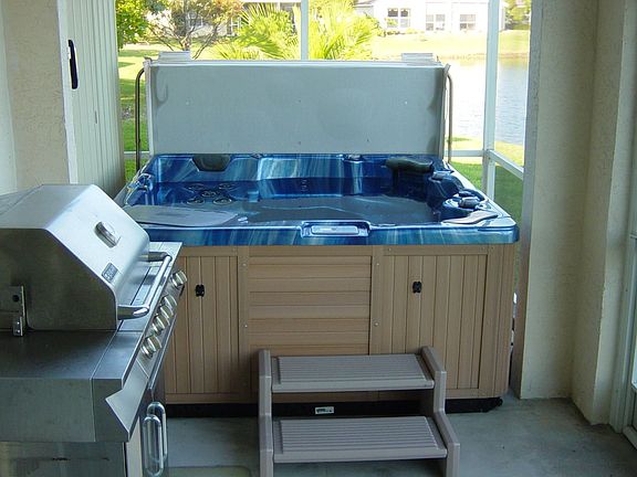 7 Person Hot Spa with BBQ, and overhead lighting.