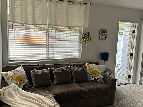 larger room with couch, faux fireplace, armoire cabinet, tv, queen size bed and closet