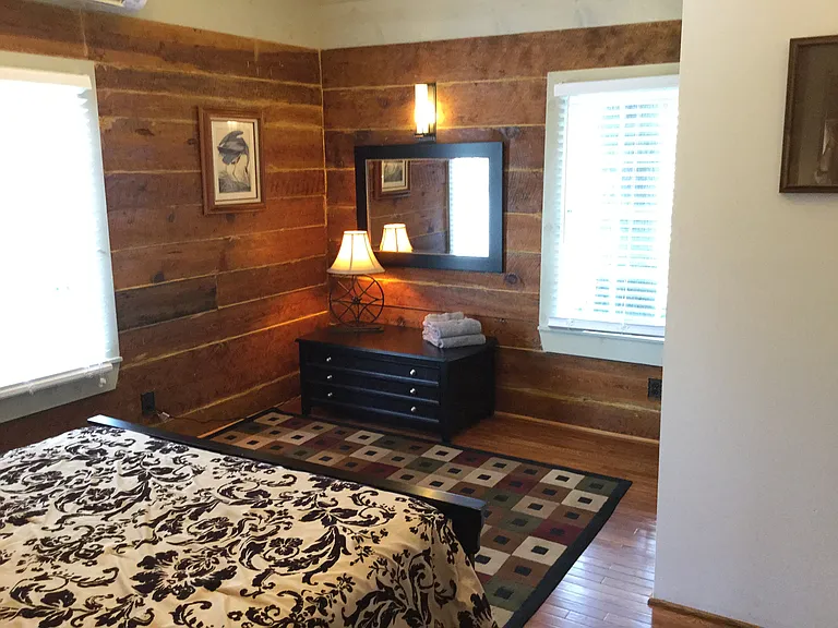 Natural light and historic wood walls create a warm and inviting guest retreat.