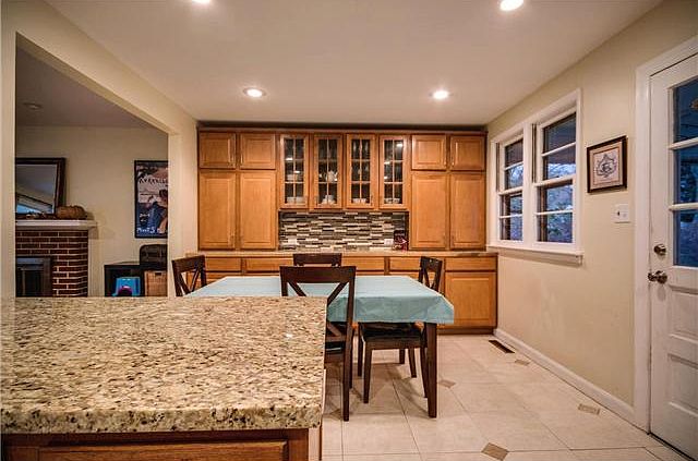 Tile floor, recessed lights, & warm wood cabinets