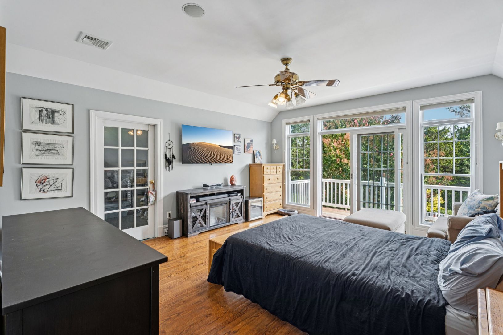 The primary bedroom adorned with oak floors, vaulted ceilings, complete with private outside acess.