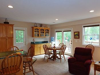 Dining area open to the living room with a sliding glass door to the deck.