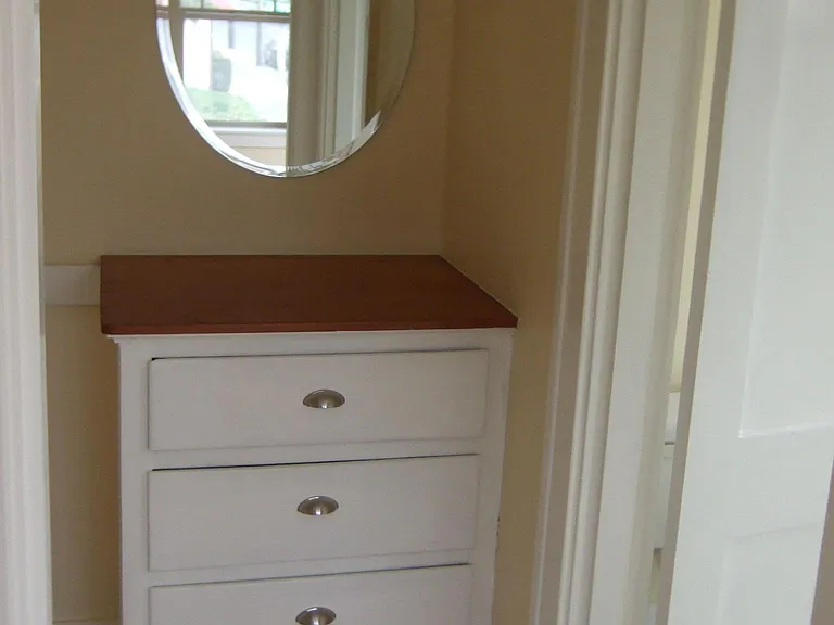 Separate walk in closet with built in drawers and mirror.