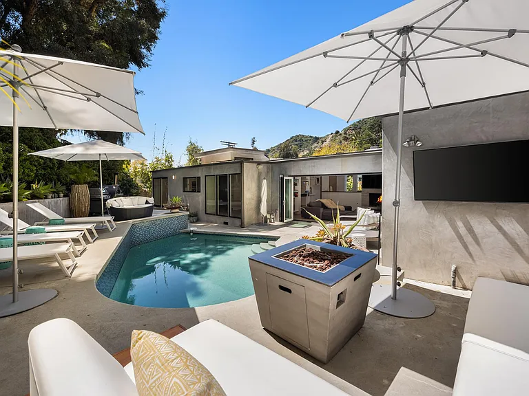 Discover the allure of the poolside fire pit, surrounded by plush seating.