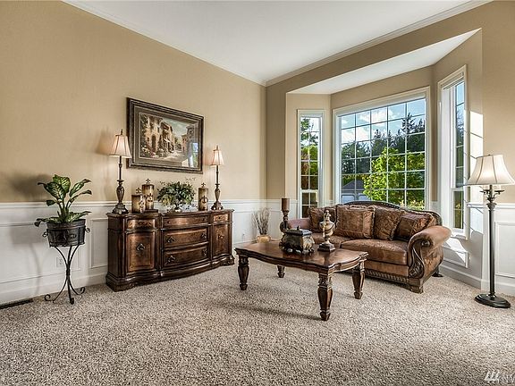 Convenient downstairs office/den with room for multiple desks and storage Notice the large window letting in tons of light and looking out over the front yard .
