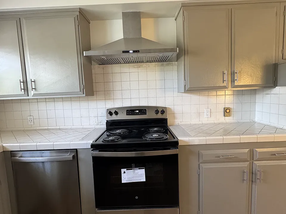 Kitchen with new stainless appliances. Cabinets are gray.