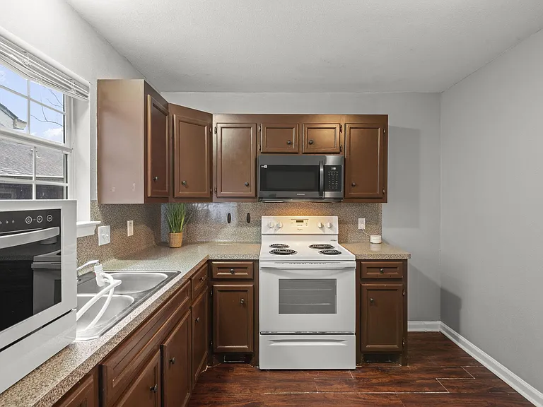 Cozy kitchen w/ all the appliances: dishwasher, microwave, fridge, stove.