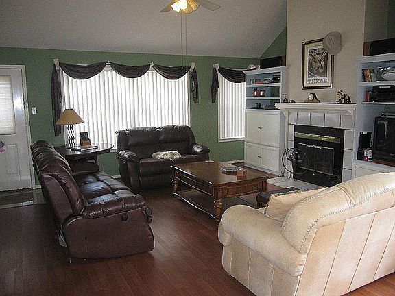 Living Room - Angle 2 showing the built-ins that stay with the home and the gas log fireplace.
