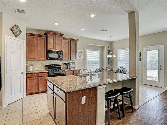 The kitchen area with a large granite area to prep your food and seats for your guests or family! You can even oversee the kids doing homework while you are preparing dinner.