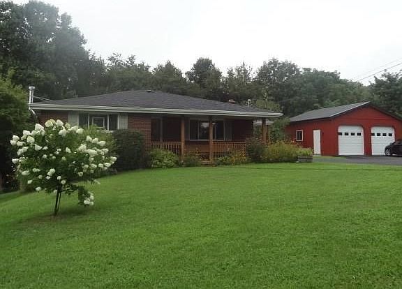 Current owners had the oversized two car garage built.  Concrete side walk leads to covered side porch.  Yard is beautiful lands