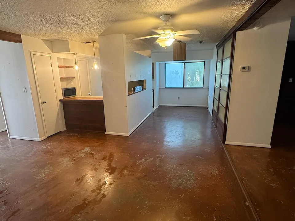View of living room, dining room, bar top area to kitchen