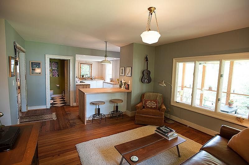 View of living room, bar/island, kitchen, half bath, and win