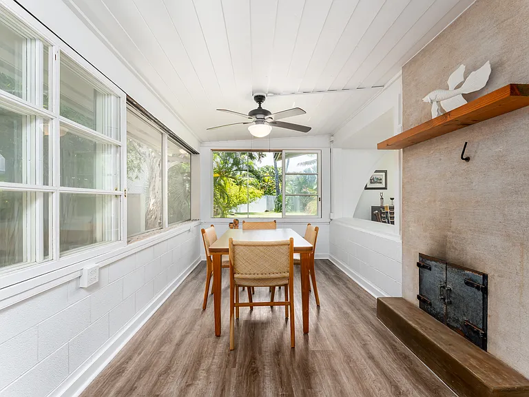 Dining area with garden views, luxury vinyl flooring, and decorative non-functioning fireplace.