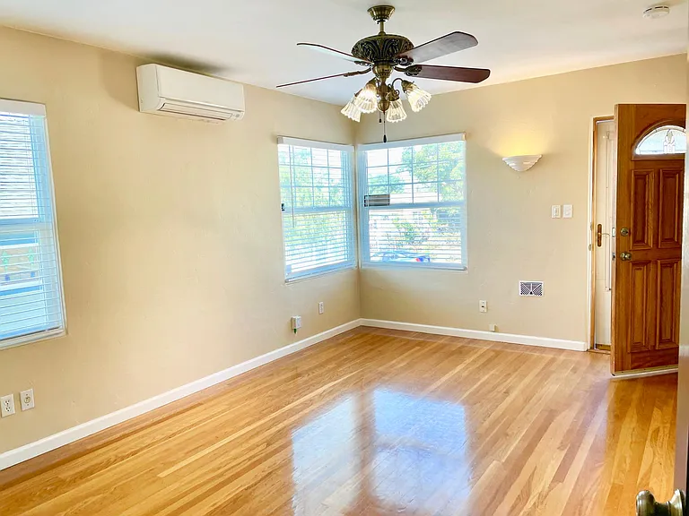 Well lighted living room w/original resurfaced oak floors, ceiling fan-light, Mitsubishi ductless ac-heating system