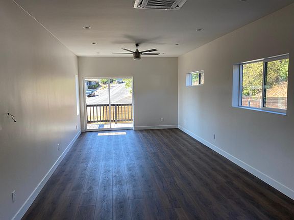 Family Room view with sliding door leading to exterior deck / backyard. House has luxury vinyl tile throughout.