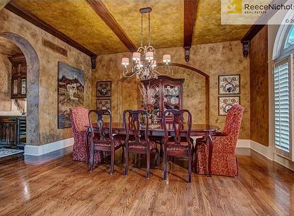 Spacious formal dining room with recessed alcove, plantation shutters and detailed beams on ceiling