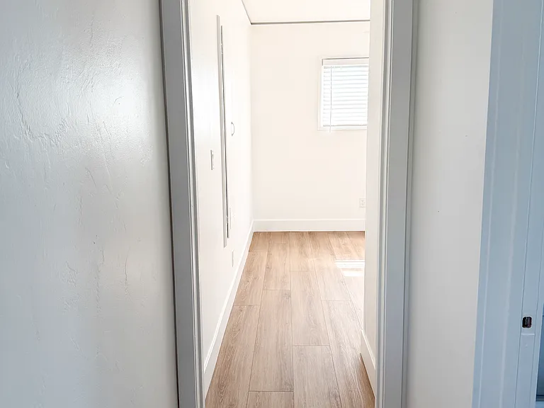 Hallway view into bedroom 1. Bathroom on the right.