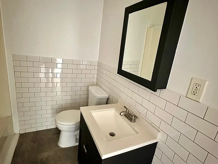 Bathrooms with white subway tiled walls, tiled floors.