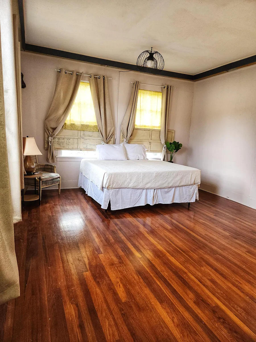 Spain room. Side yard view with 4 windows, Queen bed, closet, wood floor, window AC/Heat unit, dedicated work station and TV - Delphine St