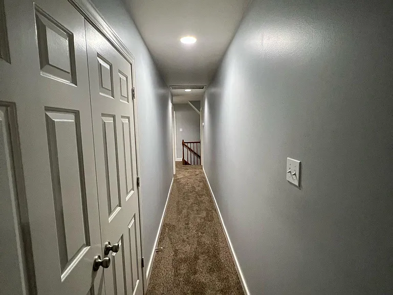 Photo looking down the hallway from bedroom 3. Washer dryer closet shown on the left