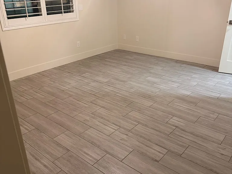 Large Primary Suite bedroom with privacy alcove entrance and sliding barn door opens to Primary bathroom. Brand new porcelain tile floors
