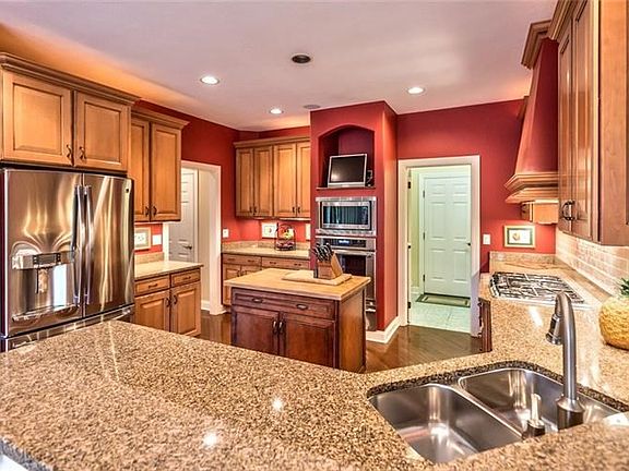 The professionally equipped kitchen with Thermador appliances forms the heart of the home, complemented by granite counters and 