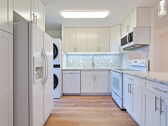 Newly remodeled open kitchen with quartz countertops, soft close cabinets, and luxury vinyl flooring