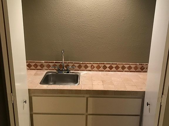 The living room also has a wet bar with sink, storage, and lighting!