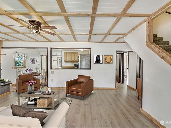 Kitchen is open to the living area. Two bedrooms on the lower and a full bathroom down the hall. Stairs to the right lead up to two additional bedrooms and bathroom.>