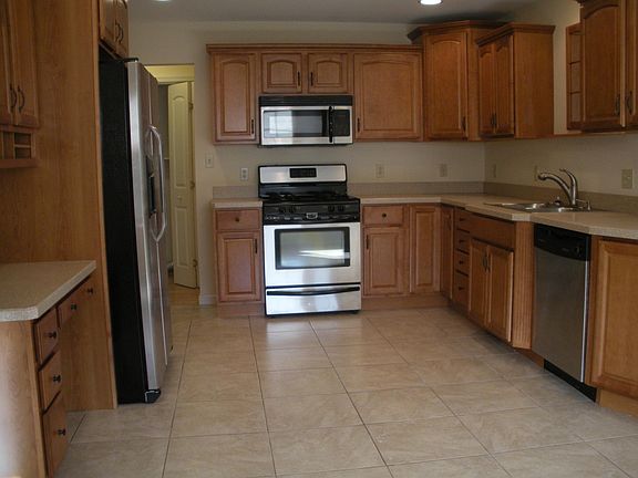 Kitchen with SS refrigerator, gas stove, microwave and dish 