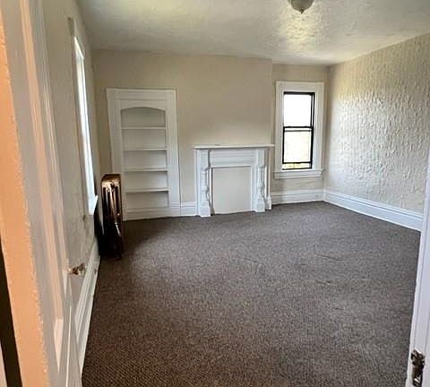 Living Room with a decorative fireplace and built-in bookcase