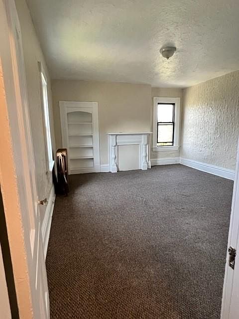 Living Room with a decorative fireplace and built-in bookcase