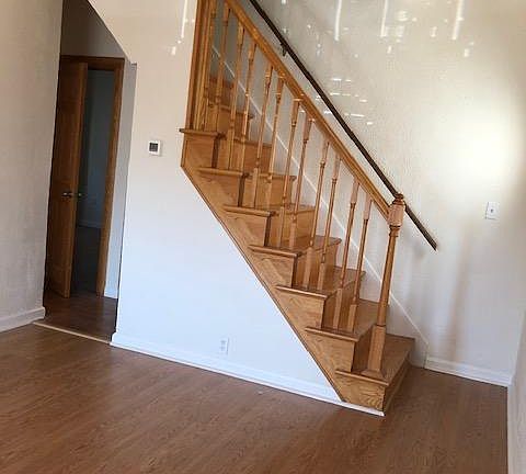 Living room with wood stairs to second floor.