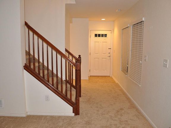 Front door entrance into living room and stairs to upper floor.