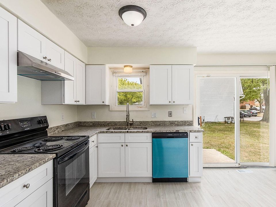 Kitchen with tile floor, granite countertops and backsplash, new cabinets, and new appliances