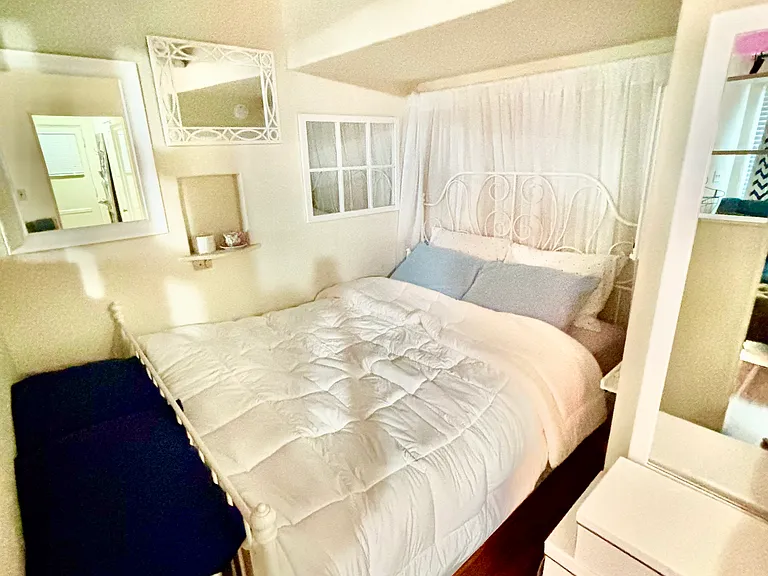 Bedroom nook, separated from living room by a built in book case.
