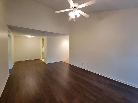 View from fireplace wall in living area looking toward dining area and kitchen. Front door is on the right
