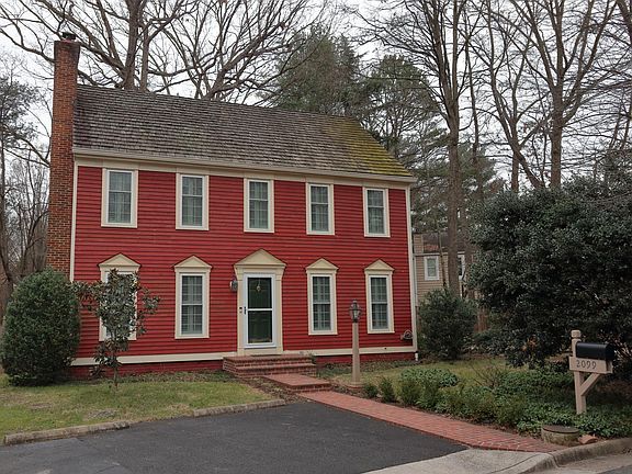 Front of house, partly showing newly asphalted parking pad. Also, new brick walkway.