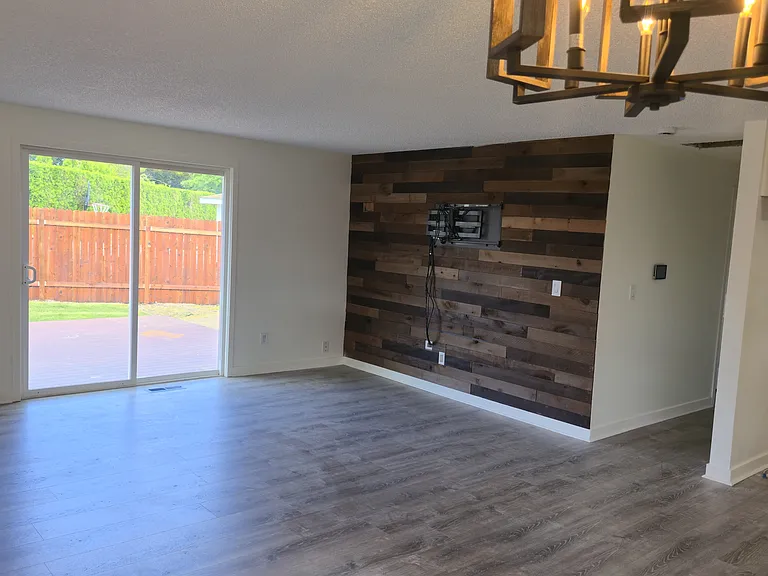 Dining room into living room, featuring sliding door into backyard with wraparound Trex composite deck.