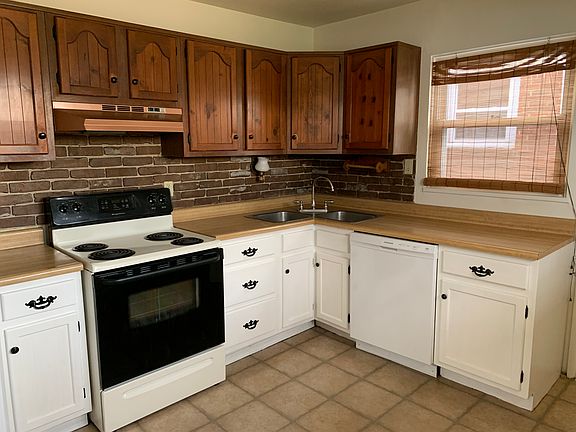 Two tone kitchen with dishwasher, electric stove and refrigerator