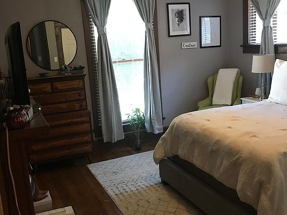 Front Bedroom is off Living Room next to a huge Magnolia tree with light blocking window treatment used by an earlier tenant.