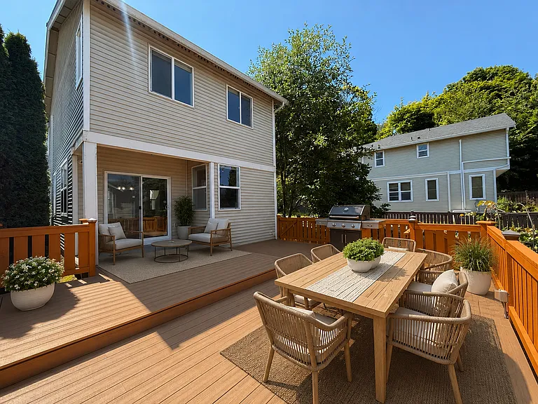 Backyard featuring a large composite deck with newly installed composite decking