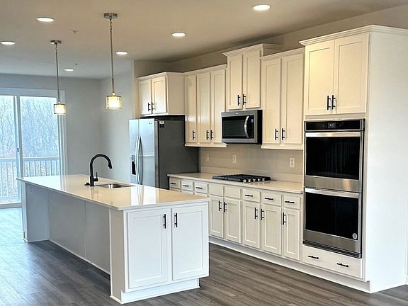 Island kitchen with white cabinets in a DRB Homes Harlow II plan at the Laurel Overlook community.