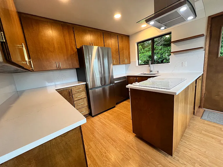 This spacious kitchen was recently updated with Quartz counters and backsplash, new fridge, hardware, sink, faucet, and new hood.