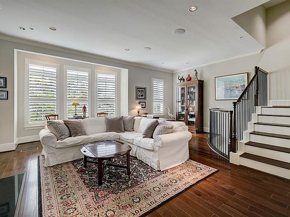 The oversized living area offers high ceilings, plantation shutters, and amazing natural light.