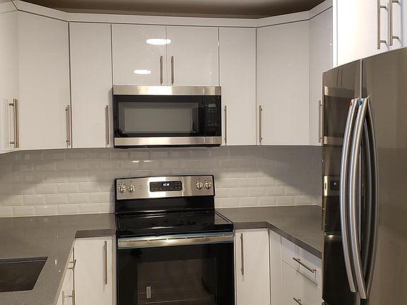 Custom made wood, white laminated, self-closing kitchen cabinets