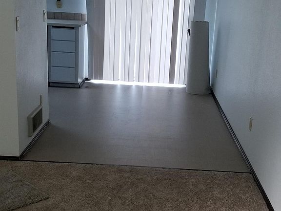 Living room looking at dining area. That roll is carpet that I will have cut and bordered to fit traffic areas of your choice.